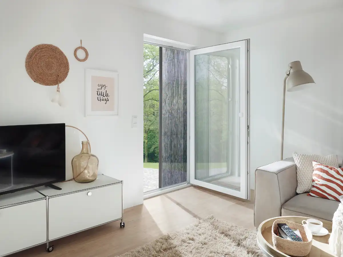 Wohnzimmer mit geöffneter Insektenschutz-Schiebetür Modernes Wohnzimmer mit geöffneter Glastür und gemütlicher Einrichtung