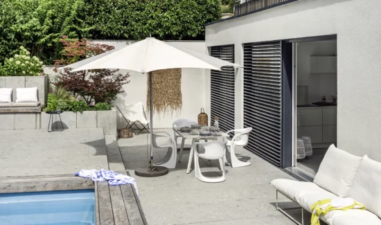Moderne Terrasse mit Pool und stilvollen Gartenmöbeln